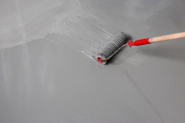 Contract painter painting garage floor to speed up selling of home clipart