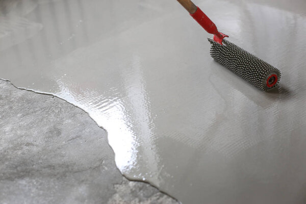 Contract painter painting garage floor to speed up selling of home