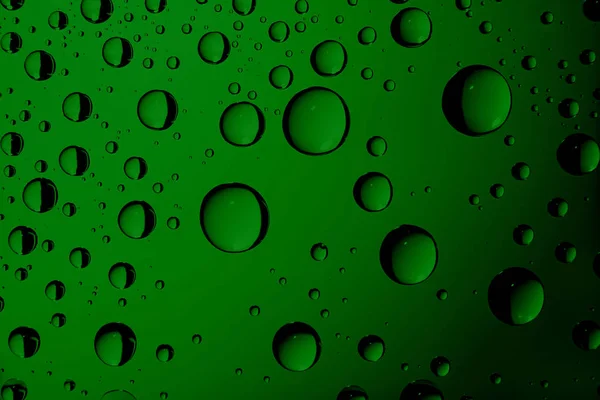 Dripped water on glass. Green abstract background