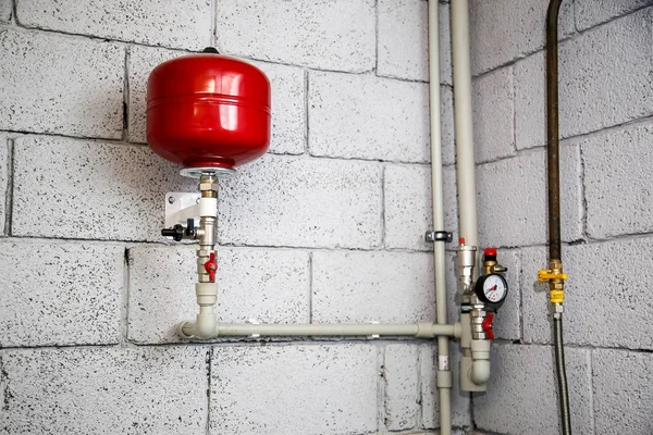 Close up of manometer, pipe, flow meter, water pumps and valves of heating system in a boiler room at home