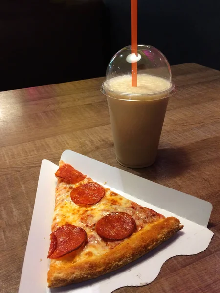 Pizza de pepperoni e bebida em um copo em uma mesa em um café. Fast food . — Fotografia de Stock