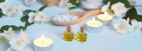 Aromatische Öle, Meersalz, Kerzen und Jasminblüten. Wellness-Zutaten für Massage und Entspannung. — Stockfoto
