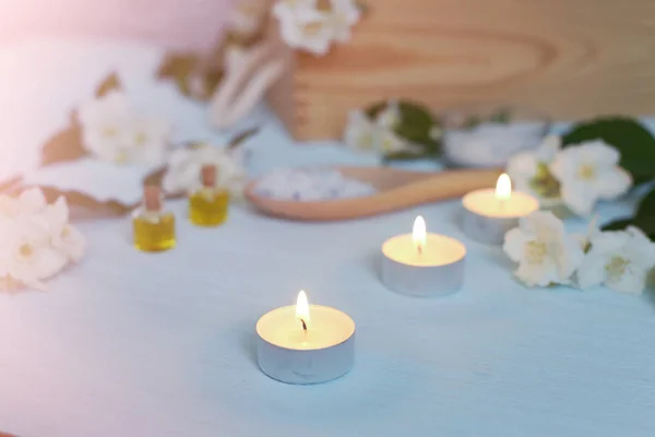 Aromatische Öle, Meersalz, Kerzen und Jasminblüten. Wellness-Zutaten für Massage und Entspannung. — Stockfoto