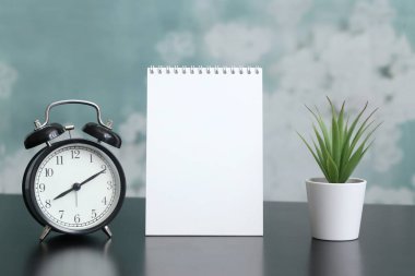 Tablo üzerinde bir pot metin, saat, ev bitki için yer ile not defteri. Günün modu, zamanlama, ücretsiz ve çalışma zamanı.