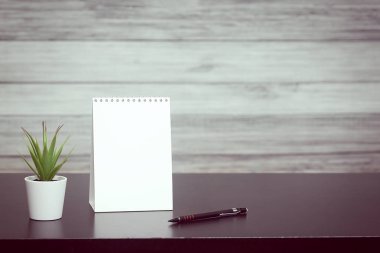 Tablo üzerinde bir pot metin, ev bitki için yer ile not defteri. Günün modu, zamanlama, ücretsiz ve çalışma zamanı.
