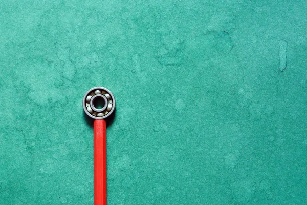 Yeşil Arka Plan Kırmızı Kalem Bir Rulman — Stok fotoğraf