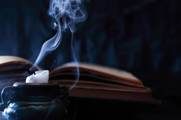 古い本の近くで死んだろうそくと青い煙とまだ生活 — ストック写真