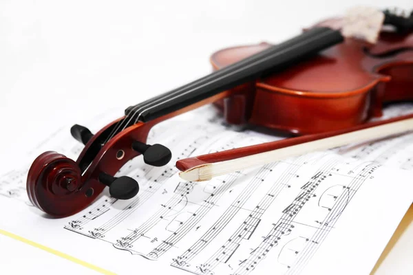 漂亮的小提琴 白色背景的音乐书籍上的弓 — 图库照片