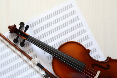 Güzel keman ve beyaz ahşap zemin üzerine boş müzik kitabı