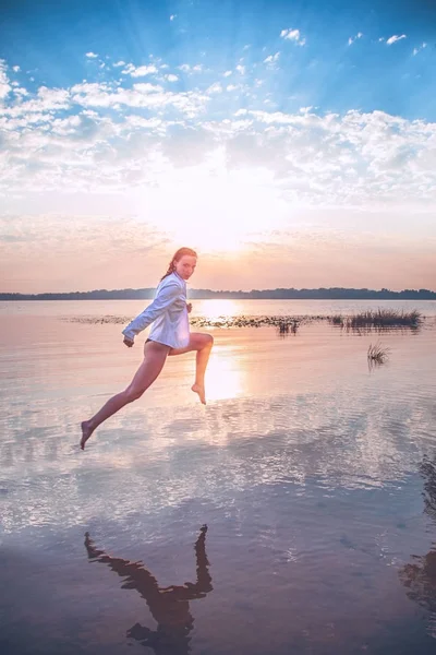 Chica Atractiva Una Chaqueta Blanca Está Saltando Sobre Agua Amanecer — Foto de Stock