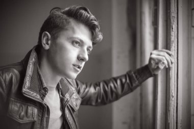 eski püskü duvar arasında bir deri ceketli bir çocuk portresi