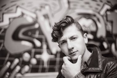 eski püskü duvar arasında bir deri ceketli bir çocuk portresi