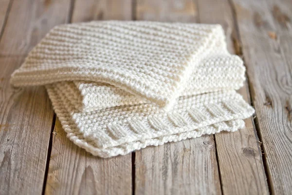 木制背景上手工编织的白色围巾 — 图库照片