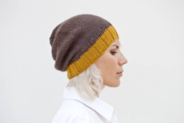 Sıcak kahverengi beanie yün örgü şapkalı güzel genç kadın.