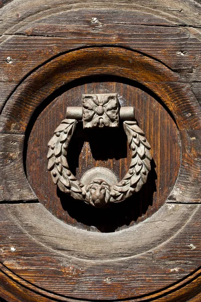 Antiga maçaneta da porta italiana no fundo de madeira marrom . — Fotografia de Stock