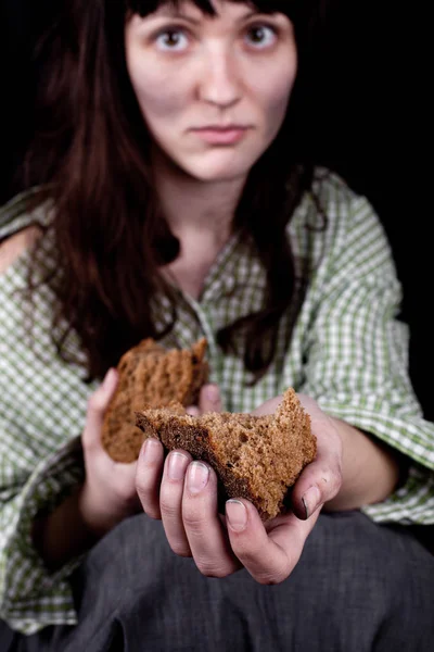 Poor beggar woman with a piece of bread. — Stock Photo, Image