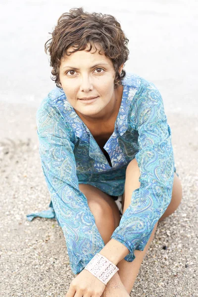 Brunet woman in blue dress on the beach. — Stock Photo, Image