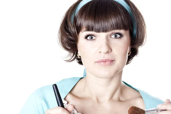 Attractive brunet woman in blue dress with two make-up brushes — Stock Photo, Image