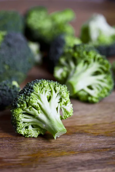 Färsk grön ekologisk broccoli närbild på träbord. — Stockfoto
