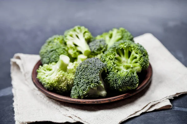 Świeże zielone brokuły organicznych w brązowe płytki i obrus lniany — Zdjęcie stockowe