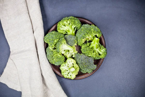 Świeże zielone brokuły organicznych w brązowe płytki i obrus lniany. — Zdjęcie stockowe