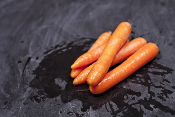 Fresh organic carrots on black background. — Stock Photo, Image