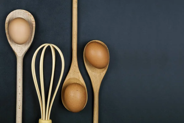 Vajíčka, dřevěná lžíce a knír. Kuchyňské nádobí pro dort, pečivo — Stock fotografie