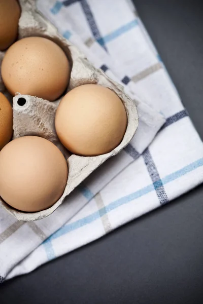 Huevos orgánicos frescos en caja de cartón y toalla de lino de cerca en ba —  Fotos de Stock
