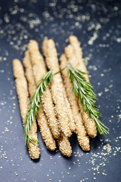 Italienska grissini eller saltade bröd pinnar med sesam och rosmarin — Stockfoto