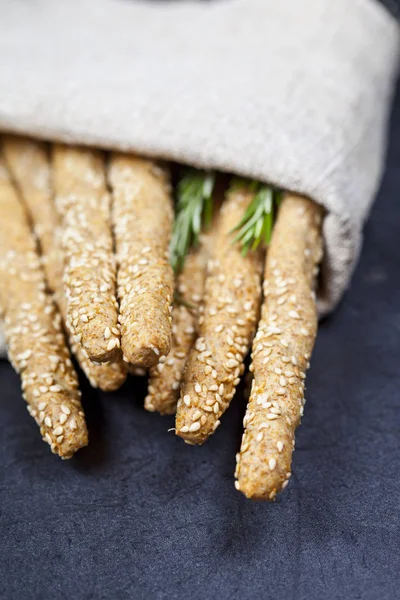 Italian grissini or salted bread sticks with rosemary herb on li — Stock Photo, Image