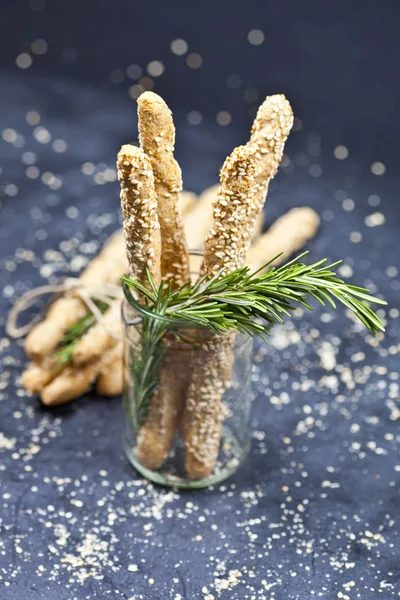 Italienska grissini eller saltade bröd pinnar med sesam och rosmarin — Stockfoto