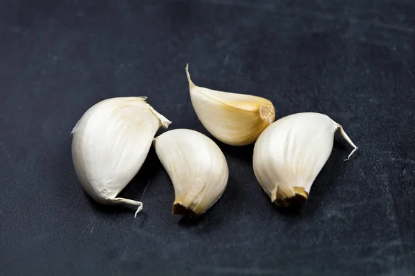 Fresh raw organic garlic on black board. — Stock Photo, Image