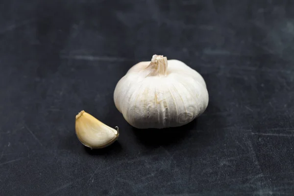 Frischer roher Bio-Knoblauch auf schwarzem Brett. — Stockfoto