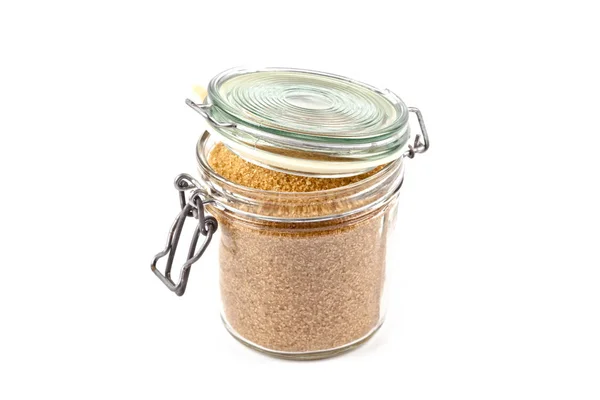 Brown cane sugar in glass jar isolated on white background. — Stock Photo, Image