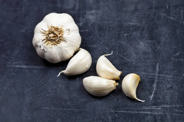 Fresh raw organic garlic on black board. — Stock Photo, Image