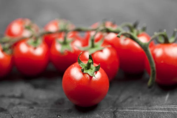 Świeże organiczne pomidory cherry bukiet zbliżenie na czarnej planszy. — Zdjęcie stockowe