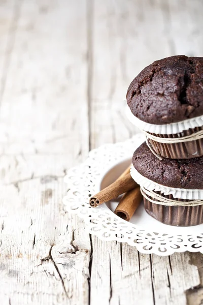 Frische Dunkle Schokoladenmuffins Mit Zimtstangen Auf Weißem Teller Auf Rustikalem — Stockfoto