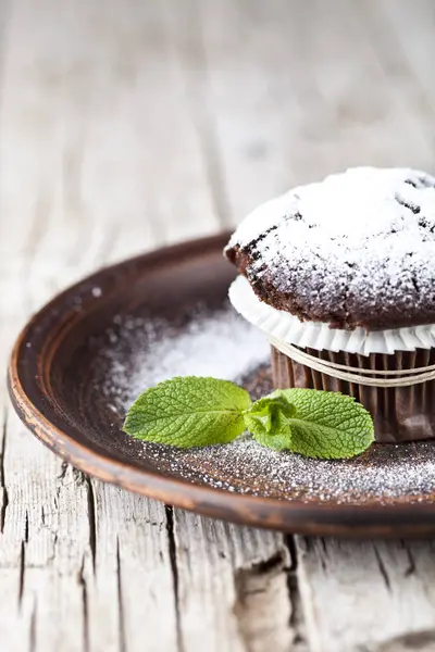 B üzerinde şeker tozu ve nane yaprağı ile taze çikolata koyu muffin — Stok fotoğraf