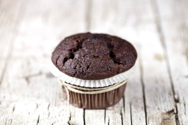 Rustik ahşap masada taze tek çikolata koyu muffin.