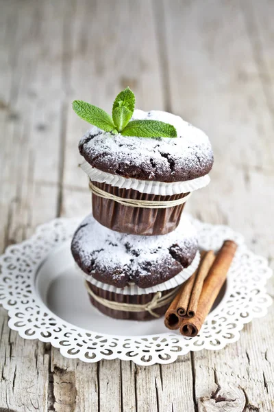 Choklad mörka muffins med socker pulver, kanel pinnar och mi — Stockfoto