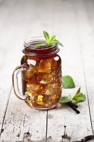 Традиционный чай со льдом с лимоном, мятными листьями и кубиками льда в гл — стоковое фото
