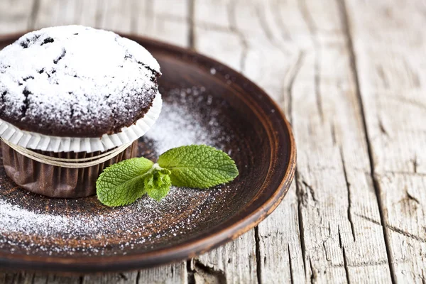 B üzerinde şeker tozu ve nane yaprağı ile taze çikolata koyu muffin — Stok fotoğraf