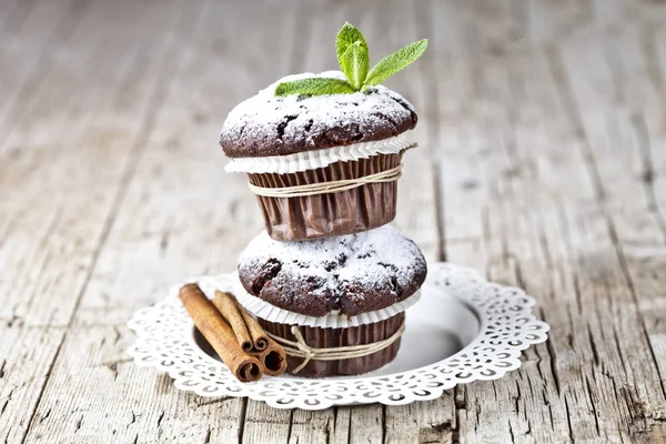 Muffin fondenti al cioccolato con zucchero in polvere, bastoncini di cannella e mi — Foto Stock