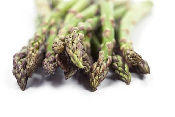 Mazzo di asparagi da giardino crudi freschi primo piano su sfondo bianco . — Foto Stock