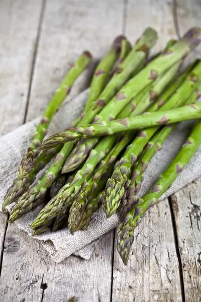 Un mazzo di asparagi da giardino freschi crudi e tovagliolo di lino — Foto Stock