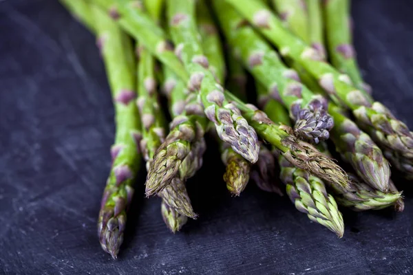 Biologico fresco giardino crudo asparagi primo piano su tavola nera backgr — Foto Stock