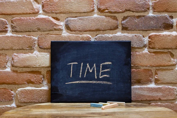 Tavola nera con la parola "Tempo" annegata a mano sul tavolo di legno o — Foto Stock