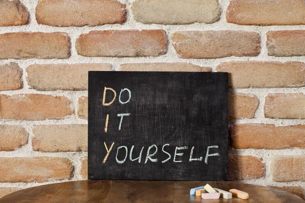 "Do It Yourself elle boğuluruz" ifadesi ile siyah tebeşir tahtası — Stok fotoğraf