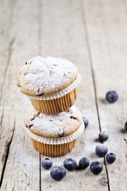 Rustik ahşap sekmesinde yaban mersini ile iki taze ev yapımı kekler