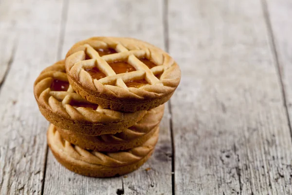 Fresh baked tarts with marmalade or apricot jam filling on on ru — Stock Photo, Image